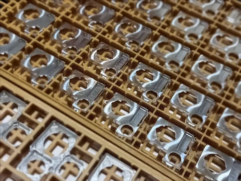 Metal smartphone camera casing components arranged.